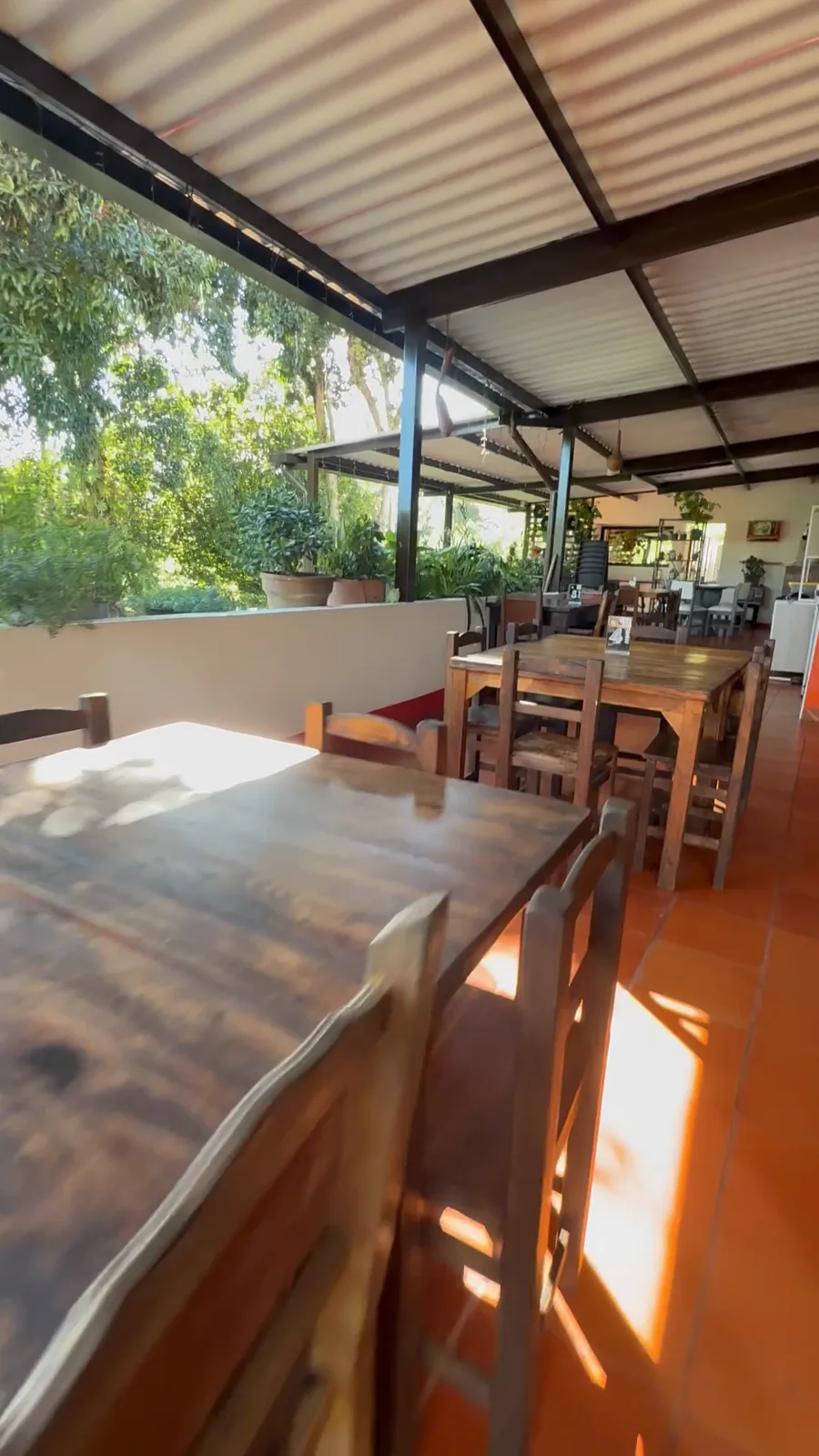 La plazoleta de La Chicharrona hoy, con sus mesas de madera y el jardín de fondo