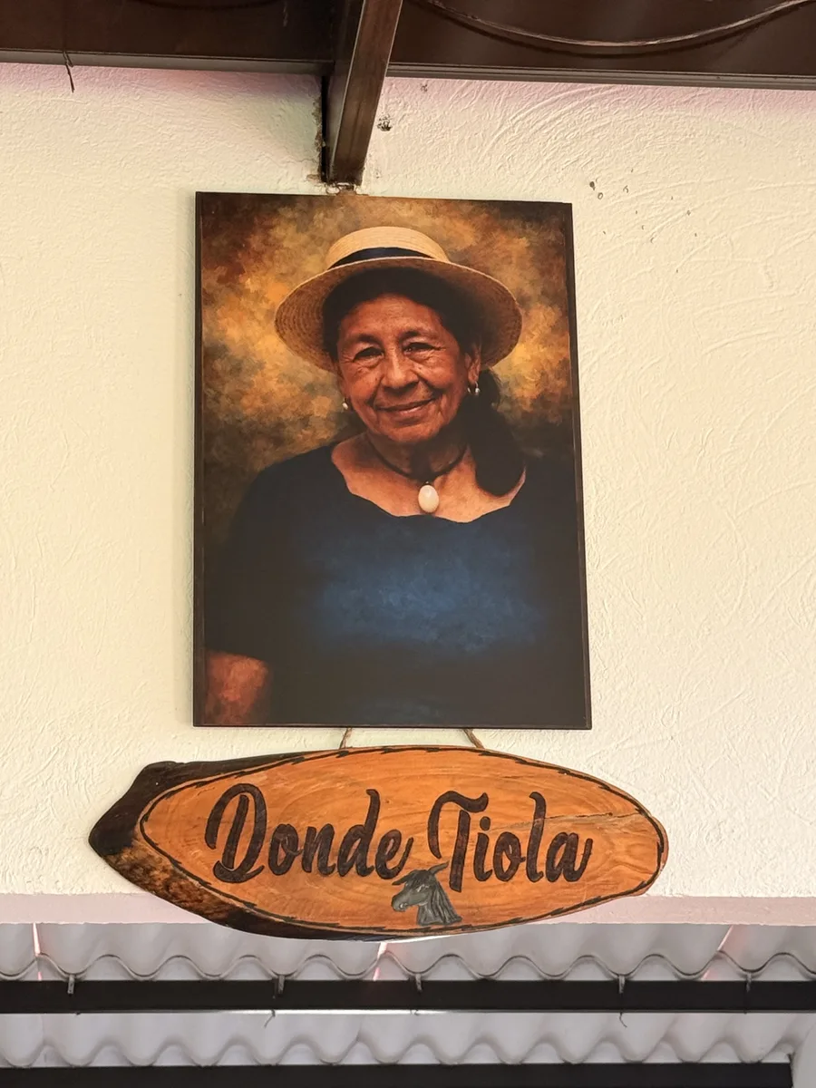 Retrato de Tiola con su sombrero y letrero de madera del salón Donde Tiola